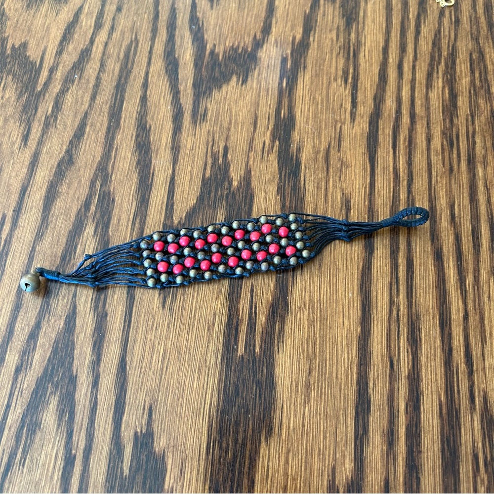 Woven bracelet on black waxed string with red and bronze colored beads